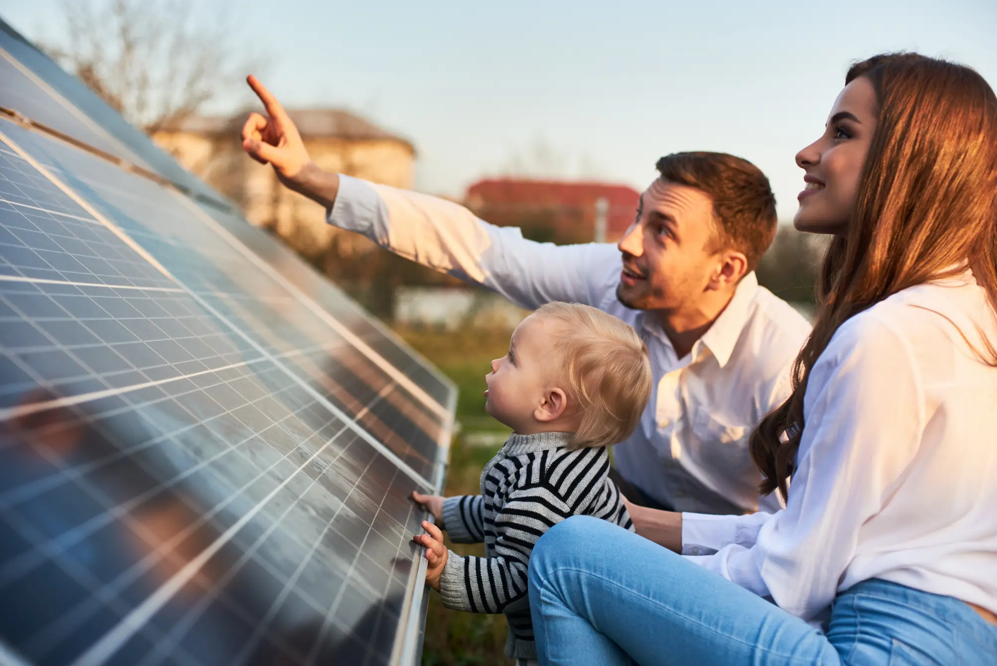Family showing a young child how solar panels work during sunset.
