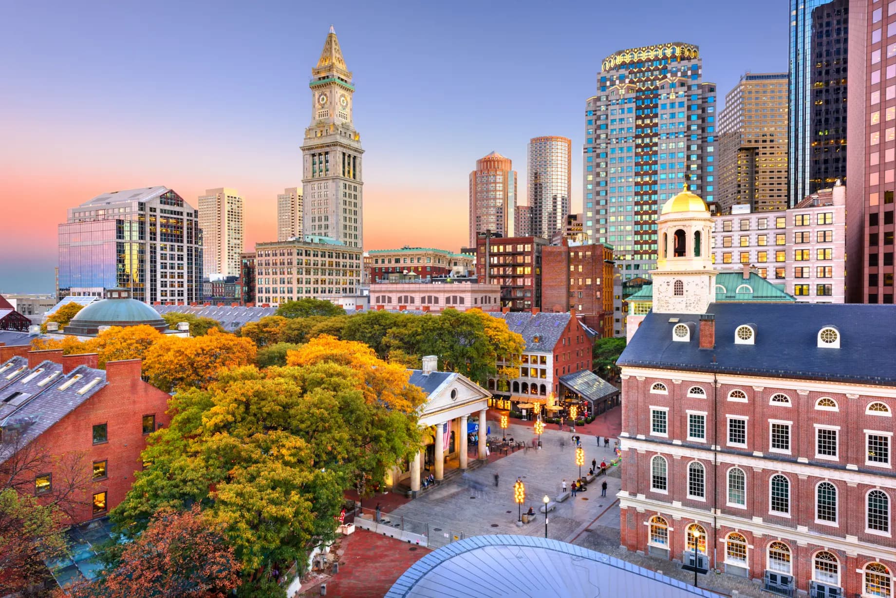Boston skyline at dusk with historic brick buildings and modern skyscrapers.