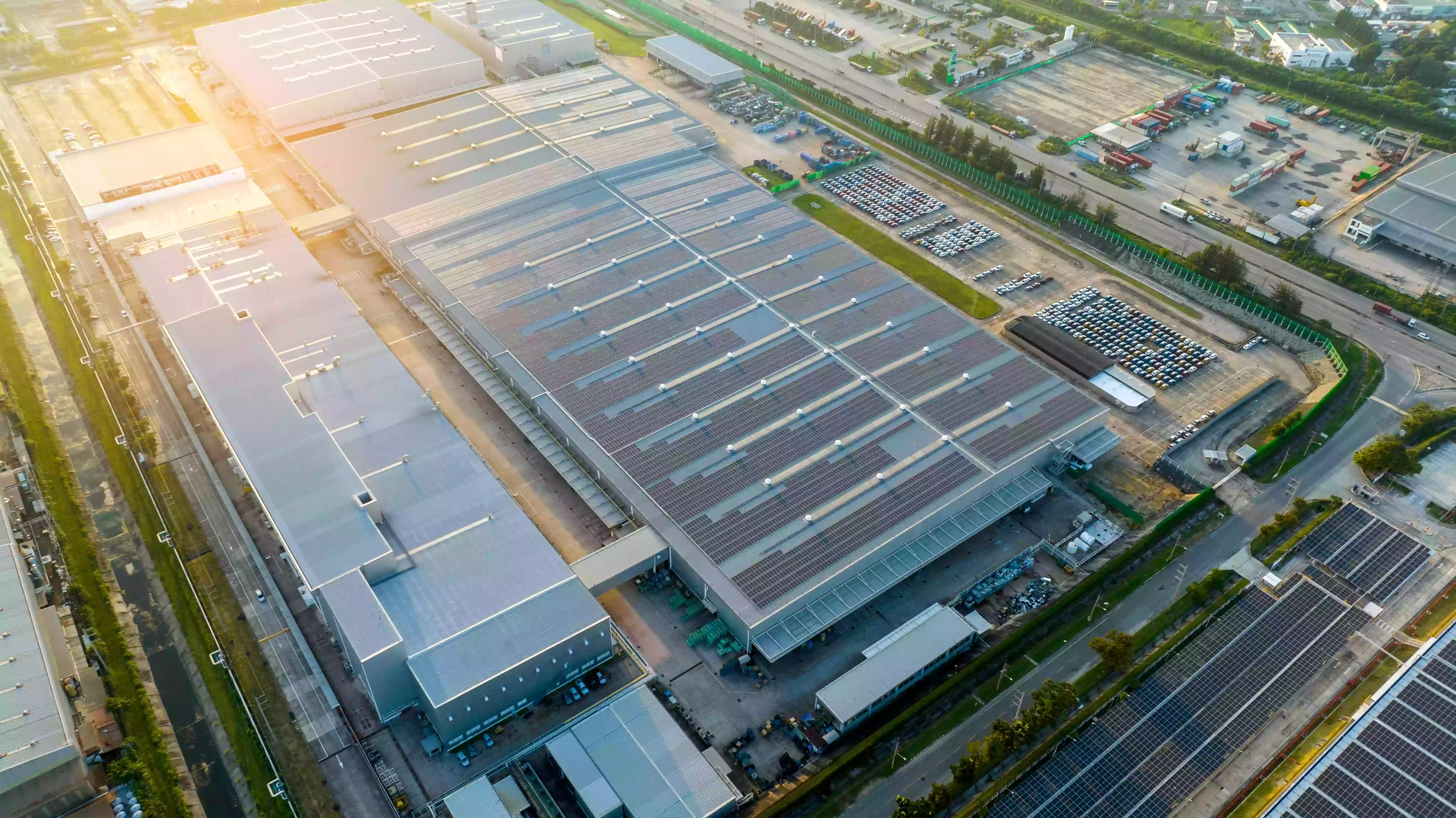 Aerial view of commercial rooftop solar panels on a large industrial facility.