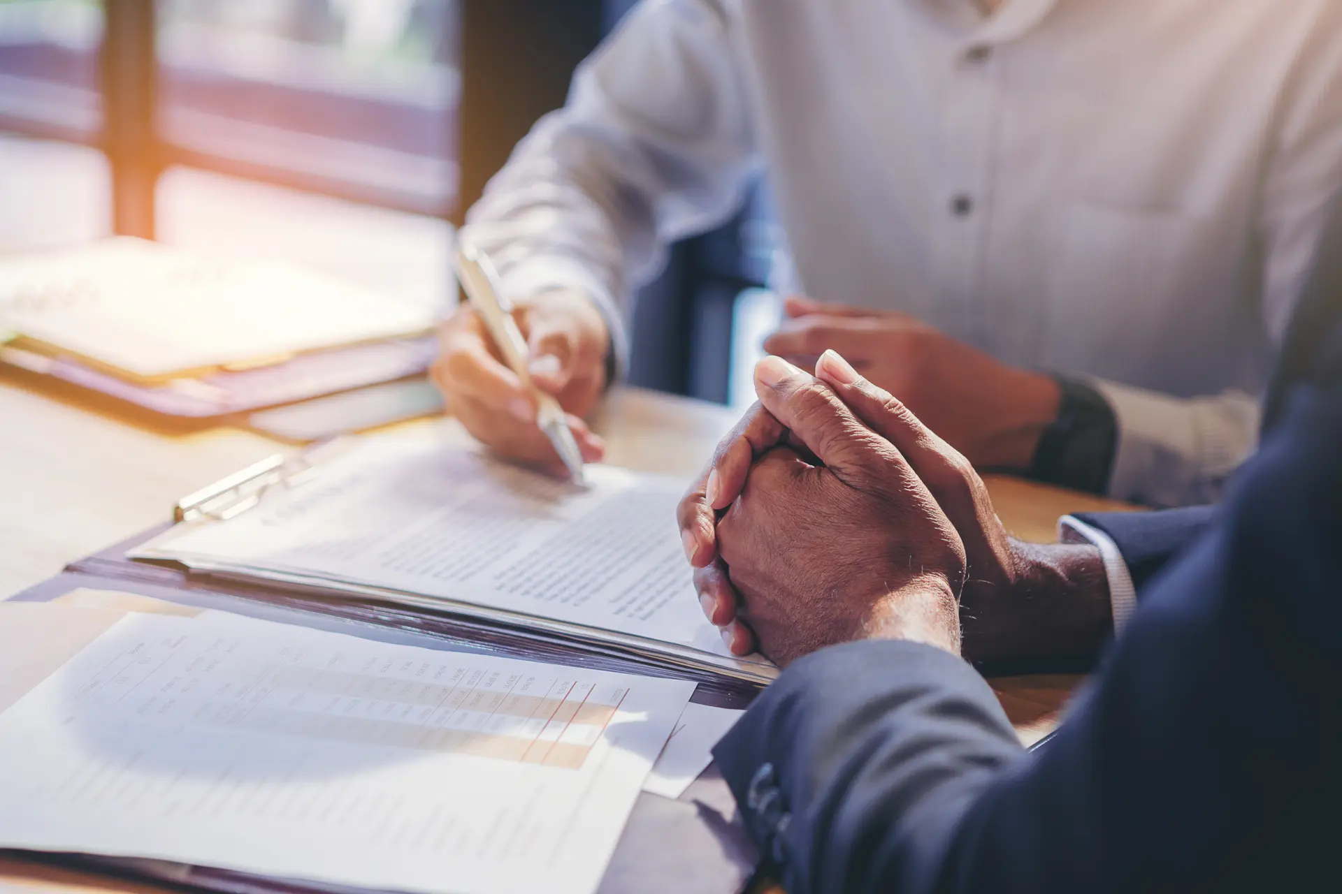 Business professionals reviewing a solar project contract at a table.