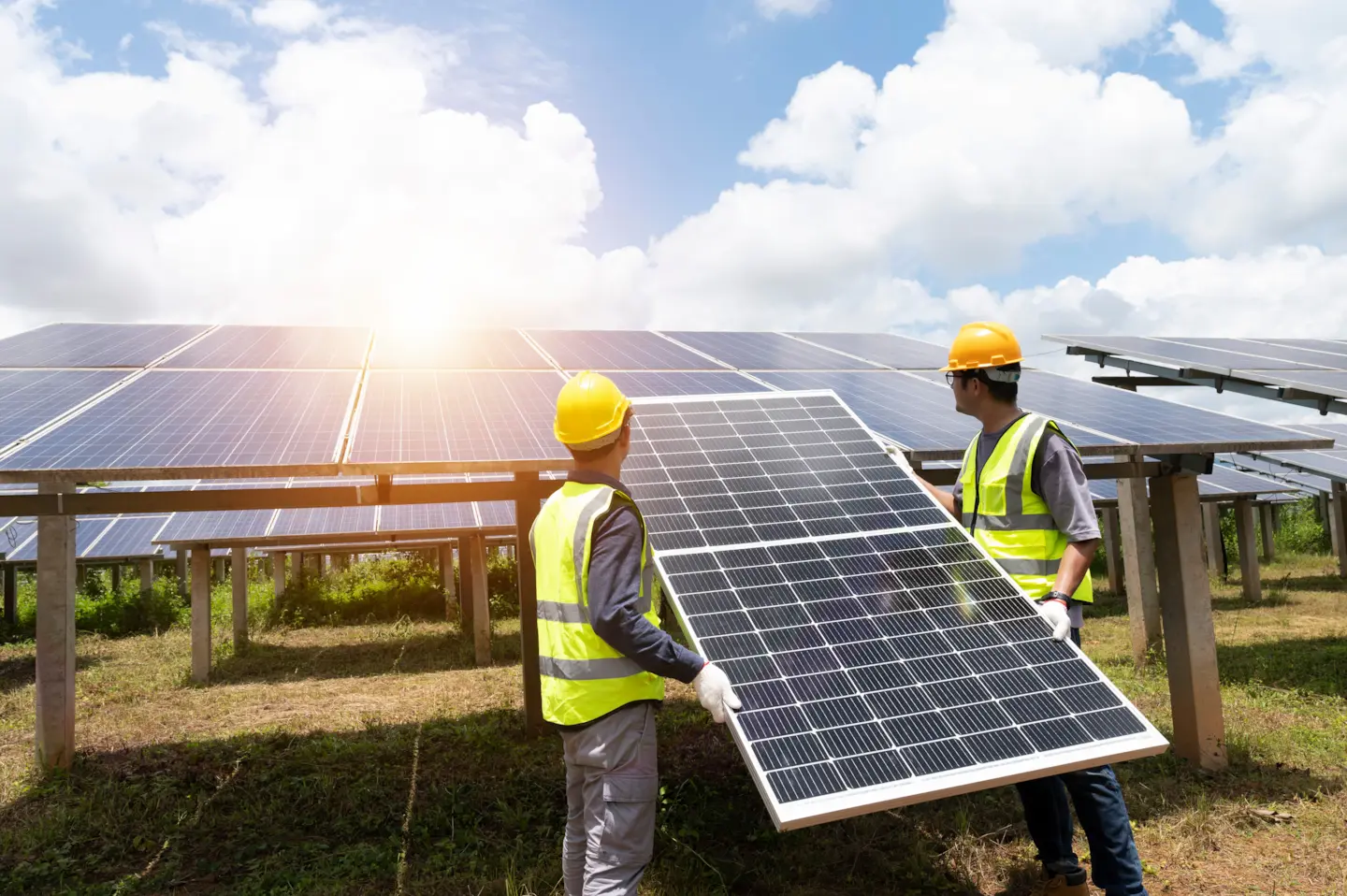 Solar workers installing panels at a commercial ground-mount project site.