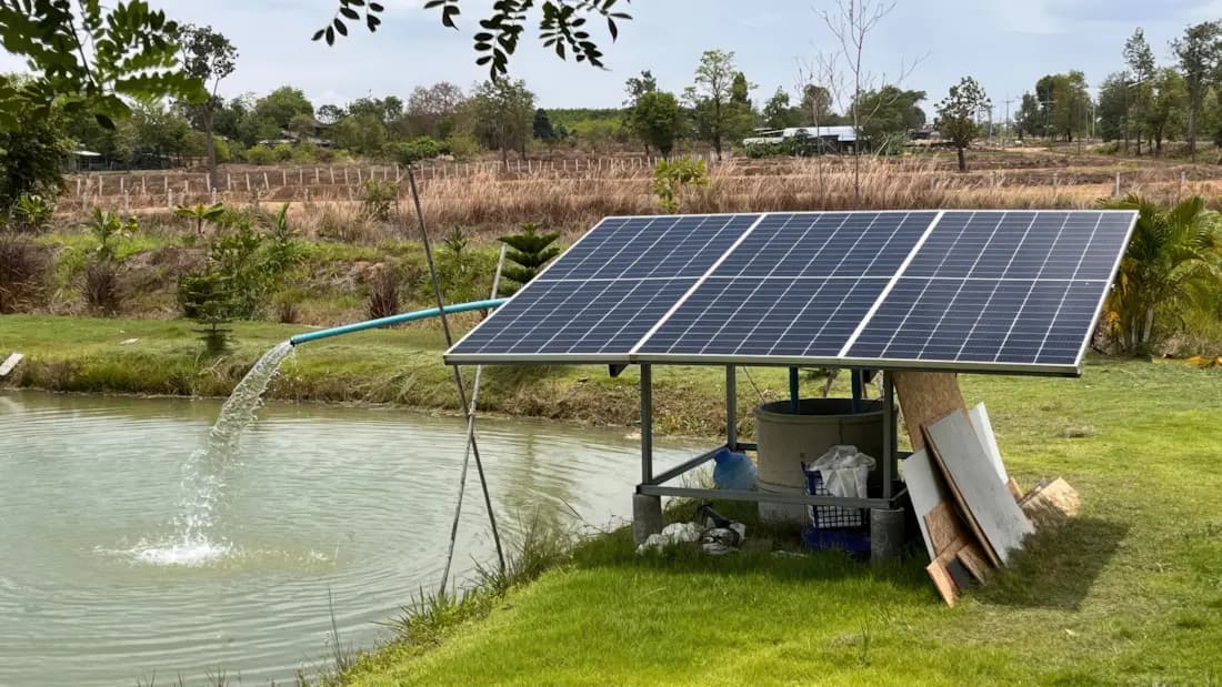 Ground-mounted off-grid solar array powering a water pump for irrigation.