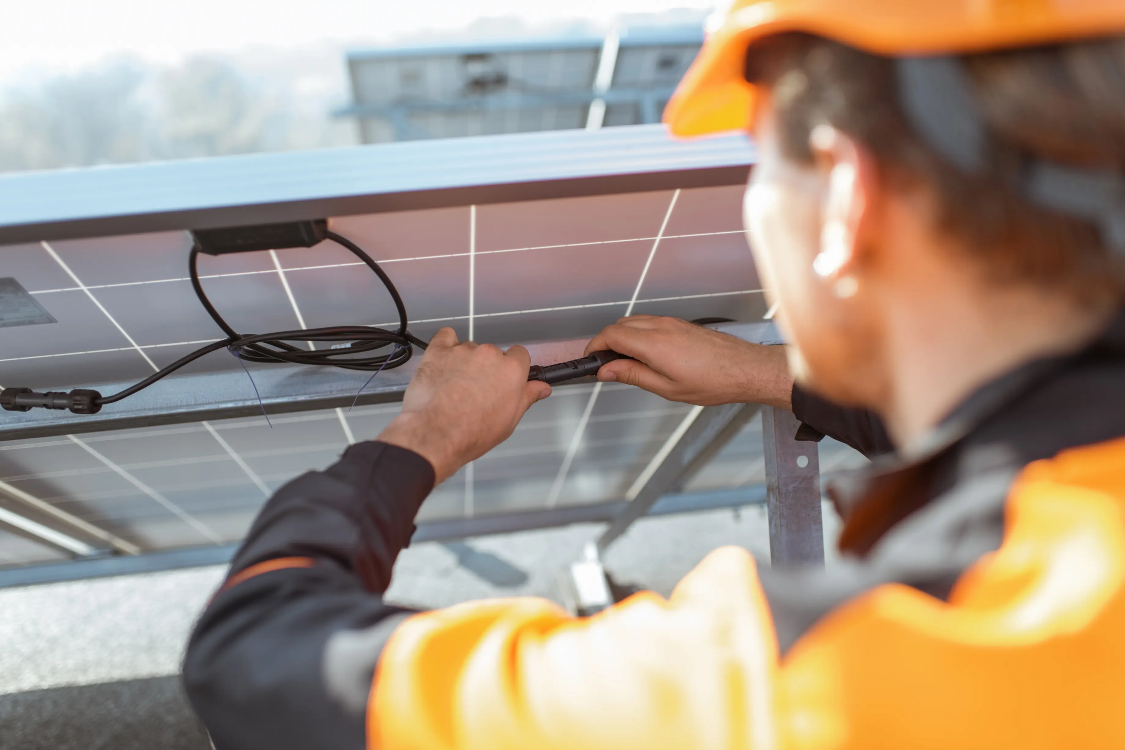 Electrician inspecting solar panel wiring and connectors during a home solar repair.