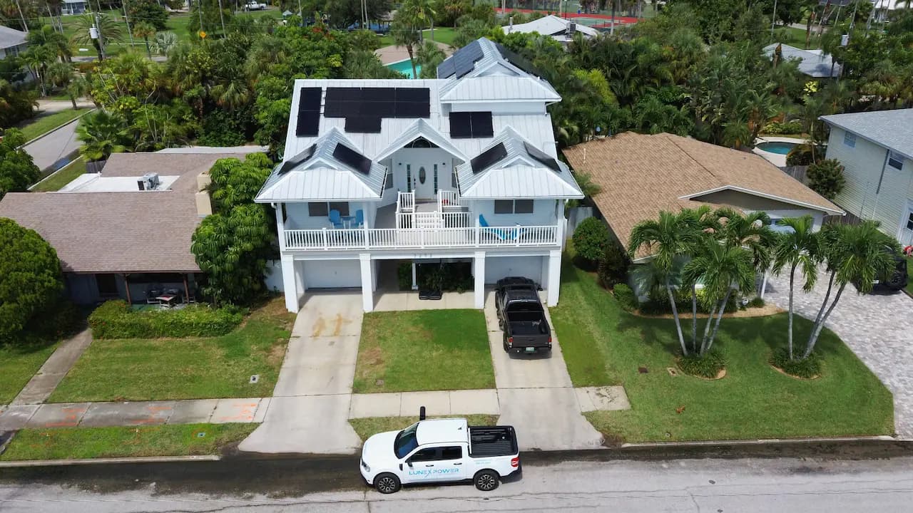 Lunex solar installation on a modern two-story Florida home with a Lunex Power truck in the driveway.